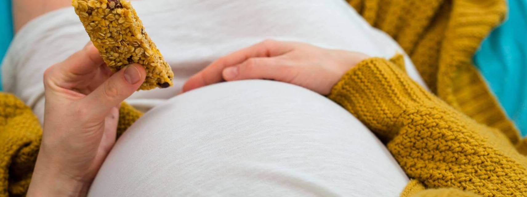 Zwangere vrouw met koekje