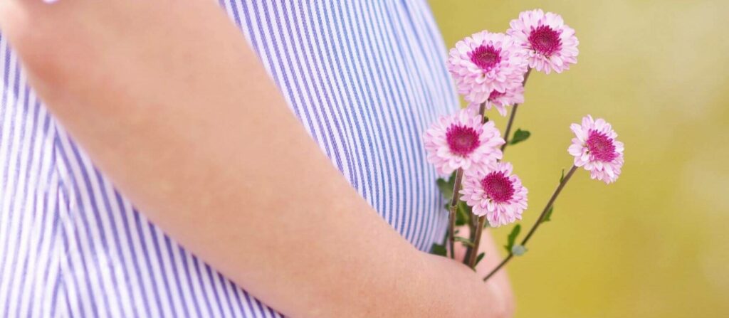 Zwangere vrouw houdt bloemen vast