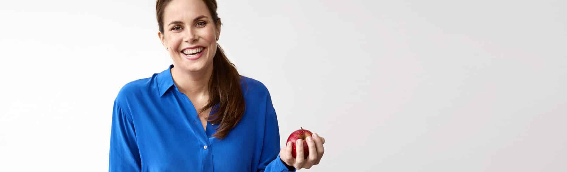 Vrouw in blauwe blouse met appel